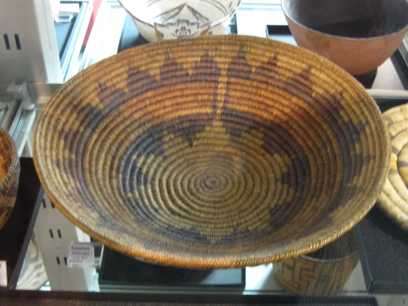 A patterned Diné (Navajo) woven basket displayed at the UBC Museum of Anthropology.