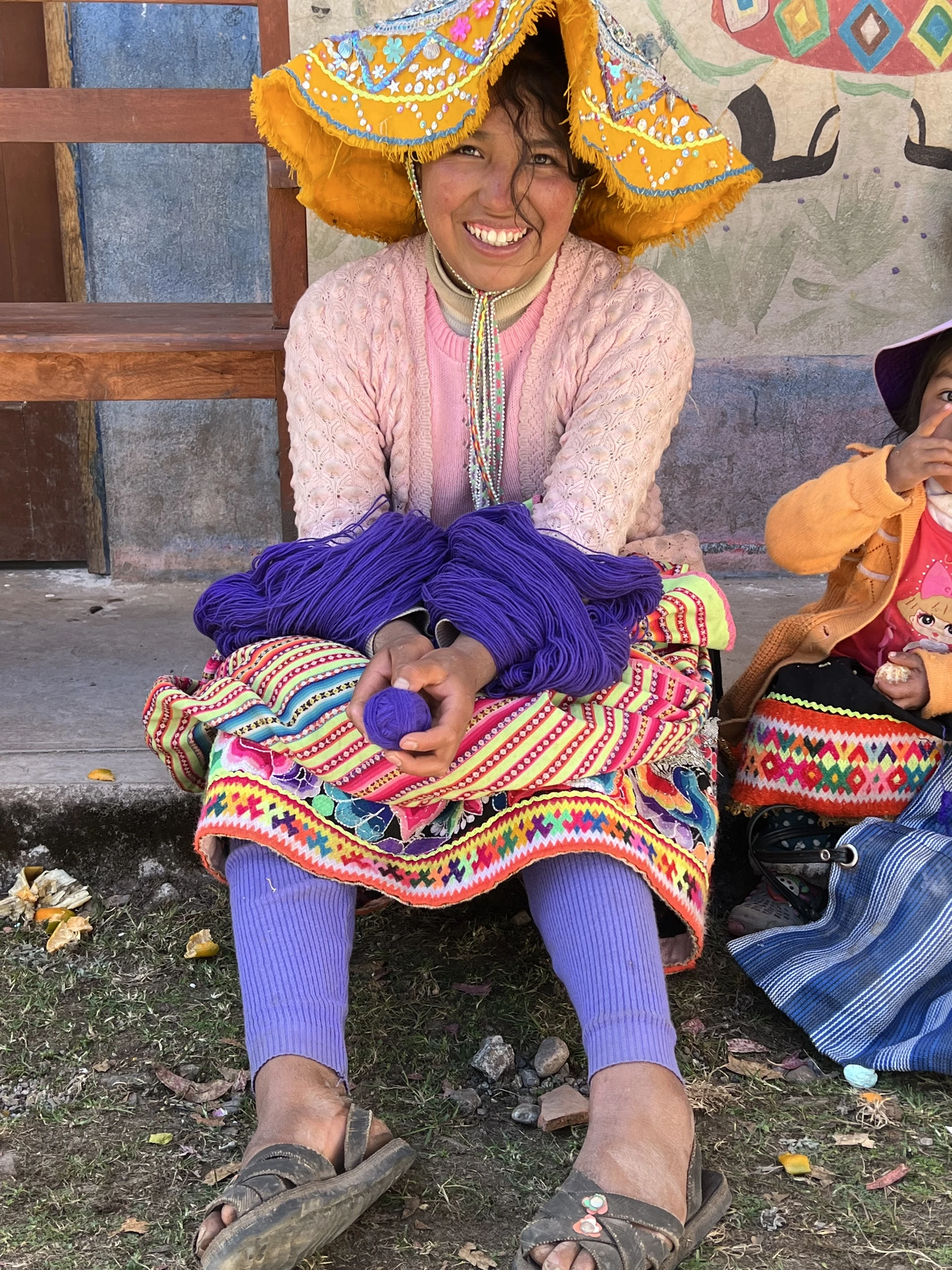 A woman in colourful Andean clothing prepares wool in Huacahuasi, Cusco, Peru
