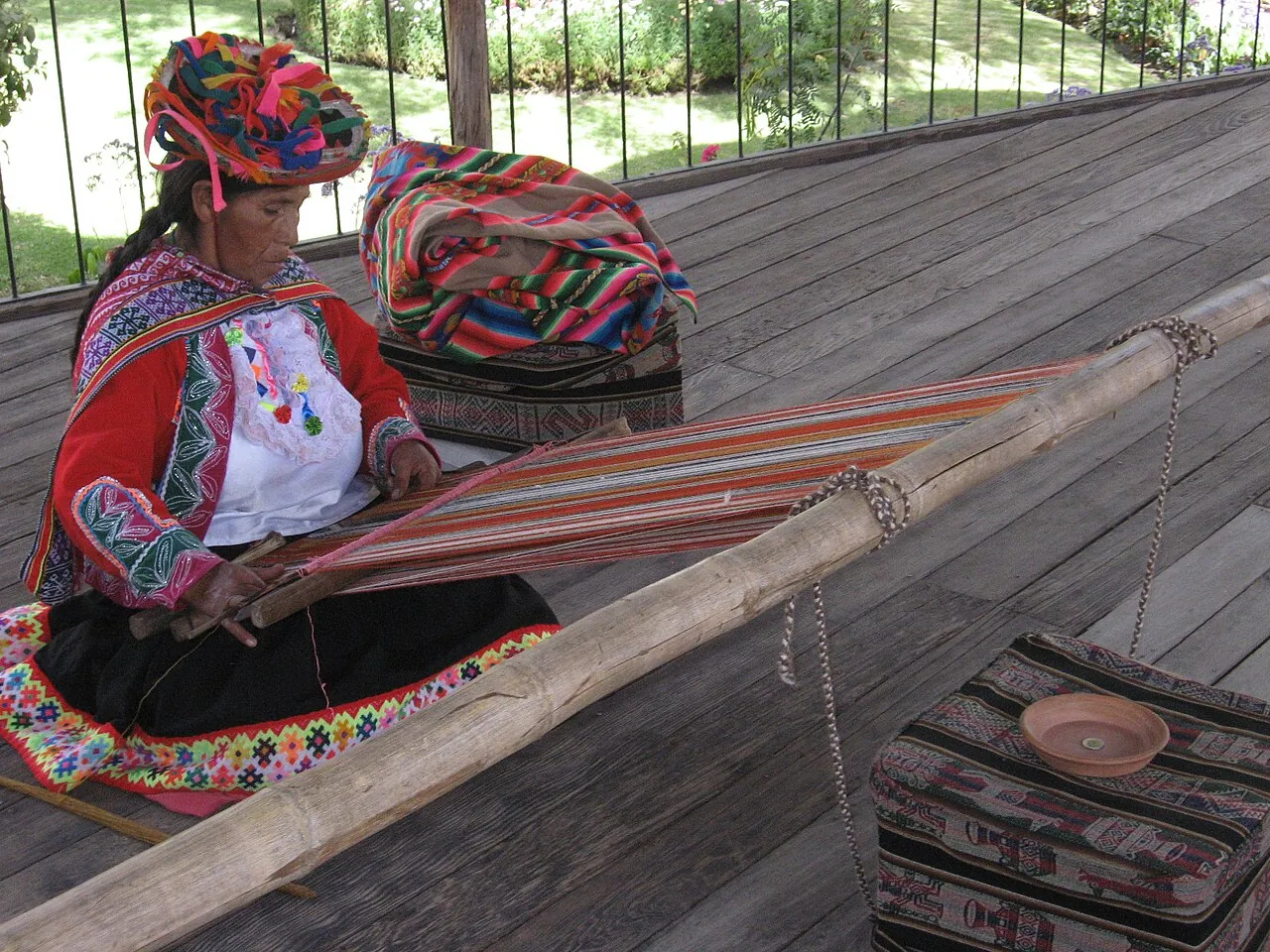 A woman in traditional dress weaves at a loom in Arequipa, Peru.