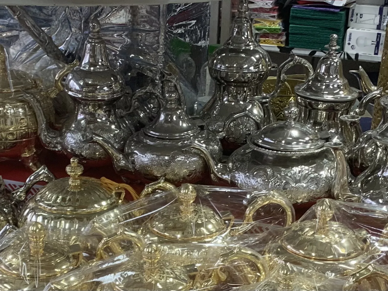 A close display of traditional Moroccan metal teapots with engraved surfaces and curved spouts.