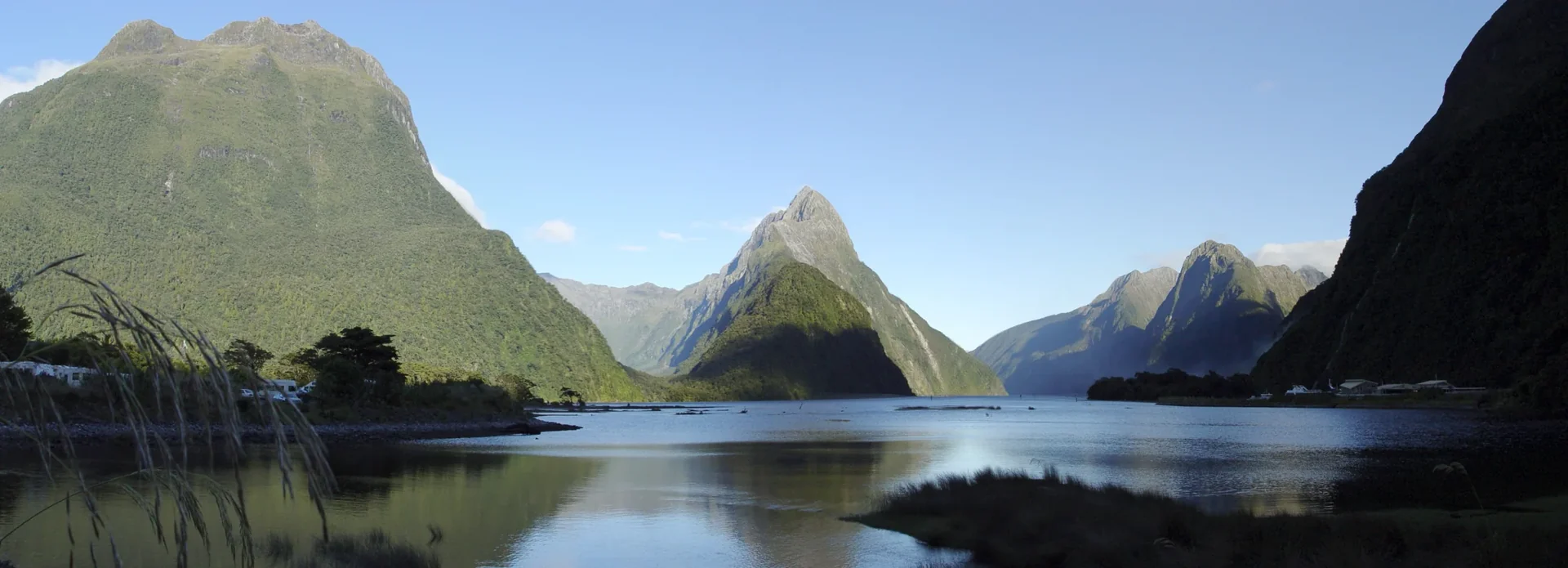Places Mitre Peak rises above deep blue water at Milford Sound in New Zealand.