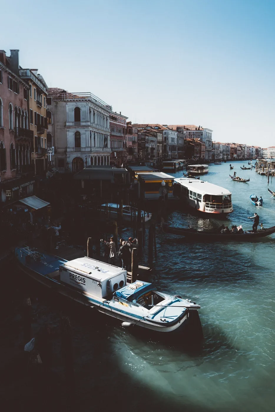 Places Historic Venetian buildings and a boat reflected in the water of the Grand Canal, Italy.