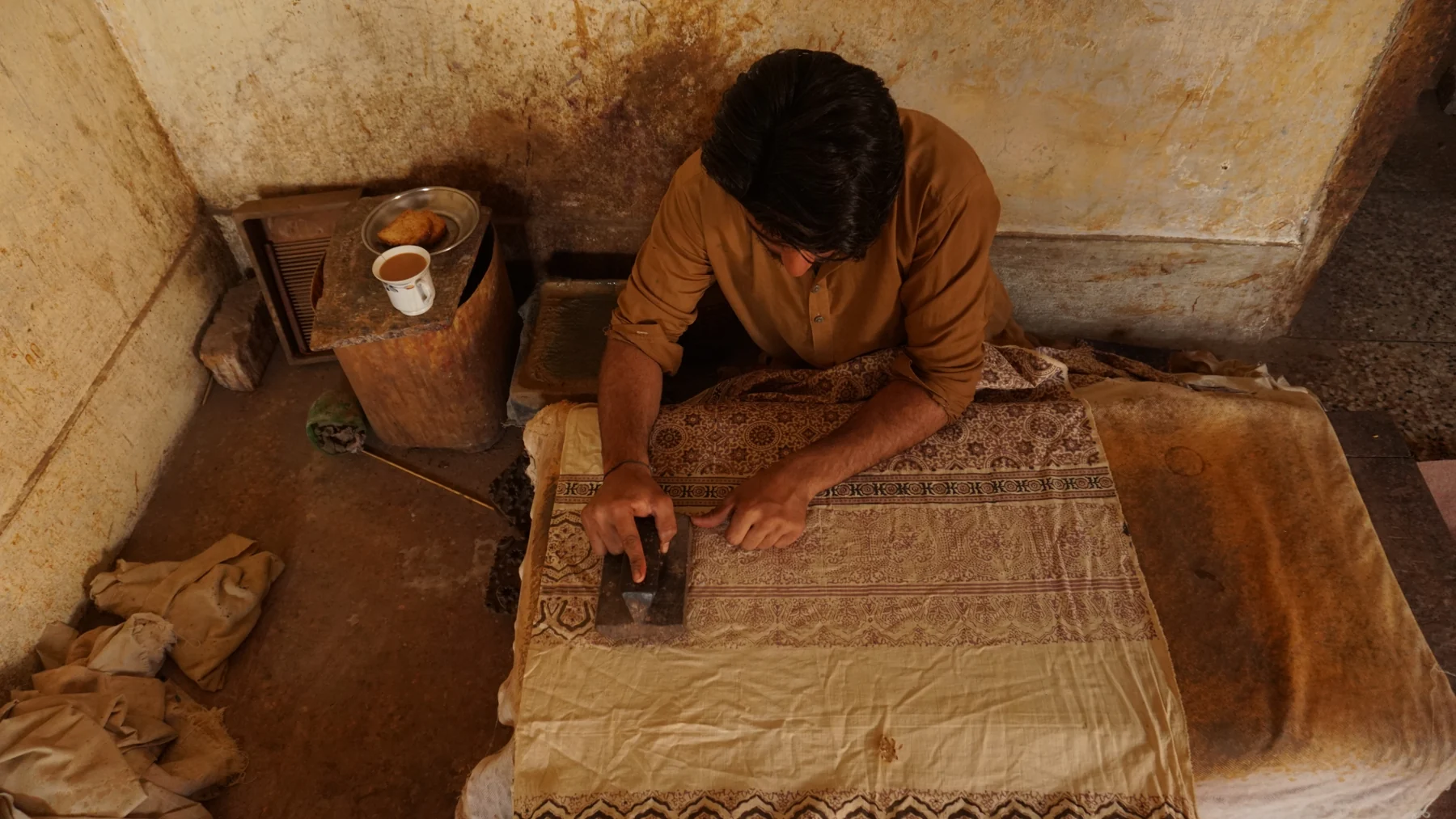 Techniques An artisan applies a wooden printing block to a patterned textile in Sindh, Pakistan.